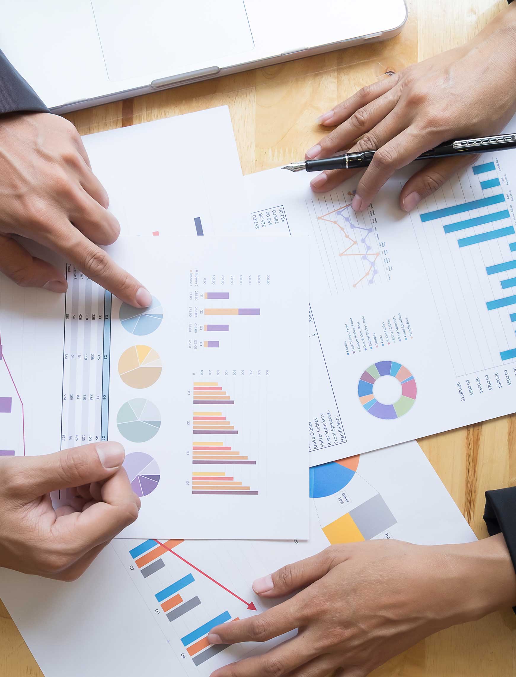 Two people discussing a qualitative research report, their hands pointing at different elements of the document.