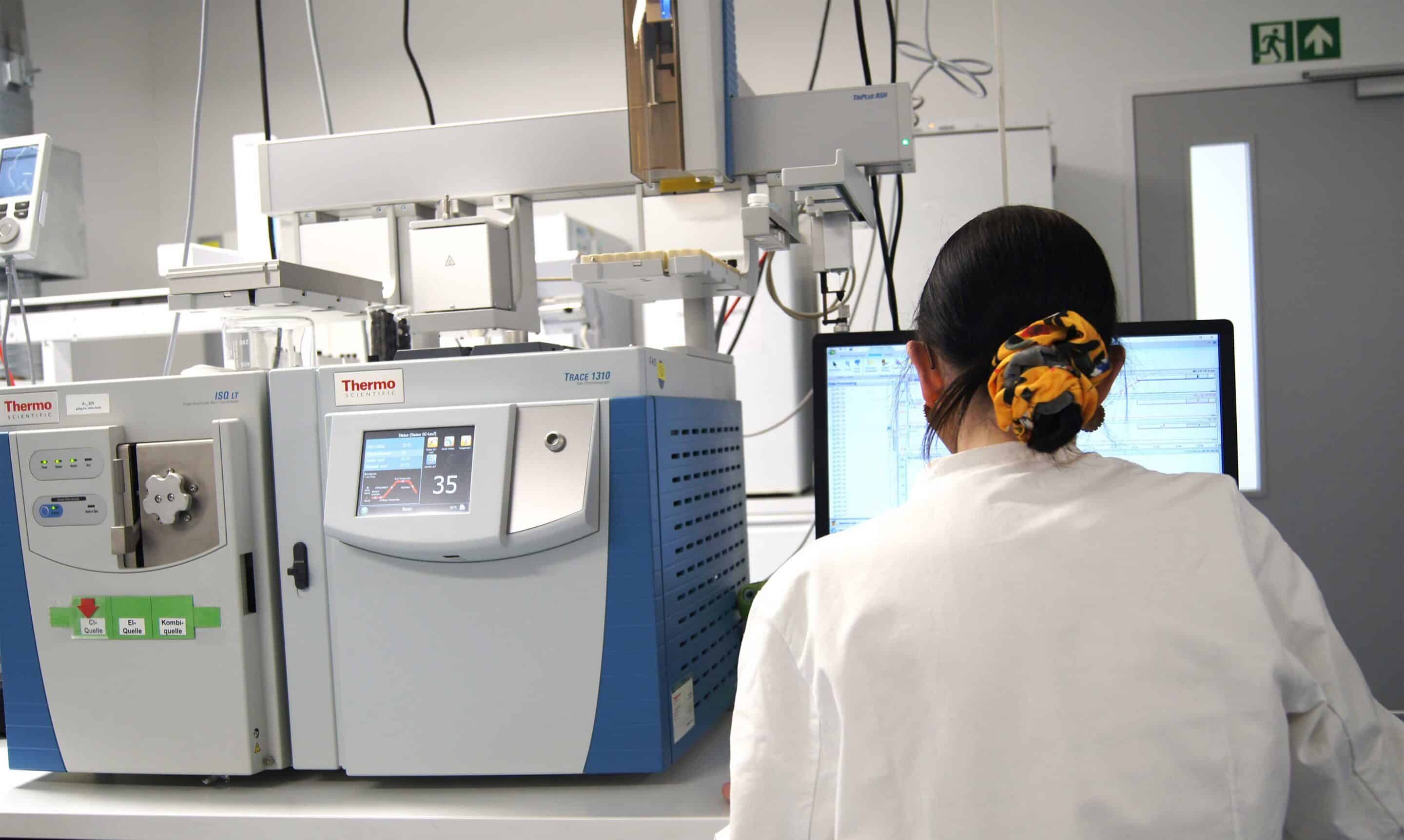 Personne vue de dos analysant les molécules émises lors d’un test en laboratoire.