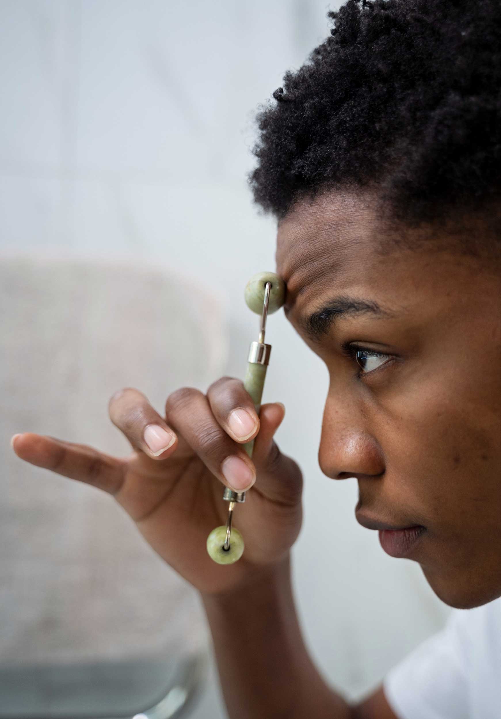 Homme utilisant un objet massant sur son visage lors d’un test de soin cosmétique