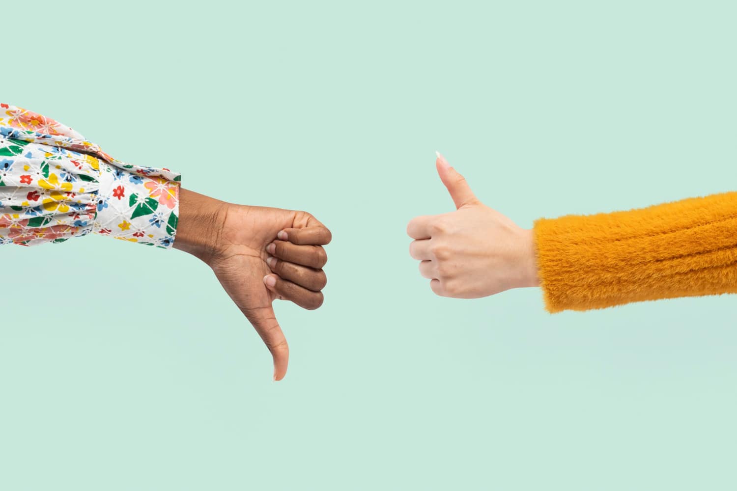 Deux avant-bras montrant un pouce levé et un pouce baissé pour illustrer le j’aime / j’aime pas des consommateurs.