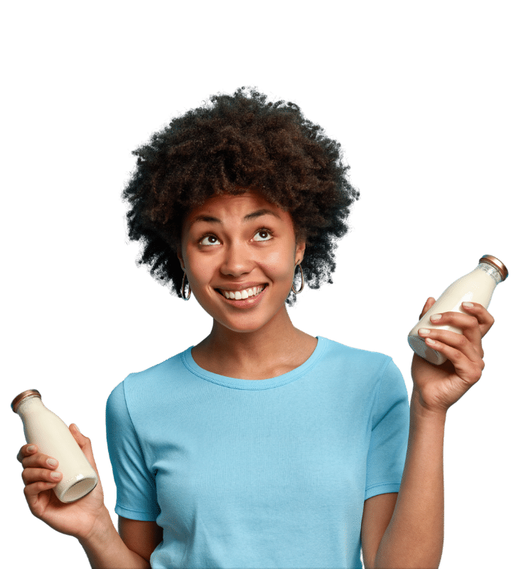 Jeune femme métisse souriante tenant deux produits laitiers différents pour illustrer la cartographie des préférences consommateurs.