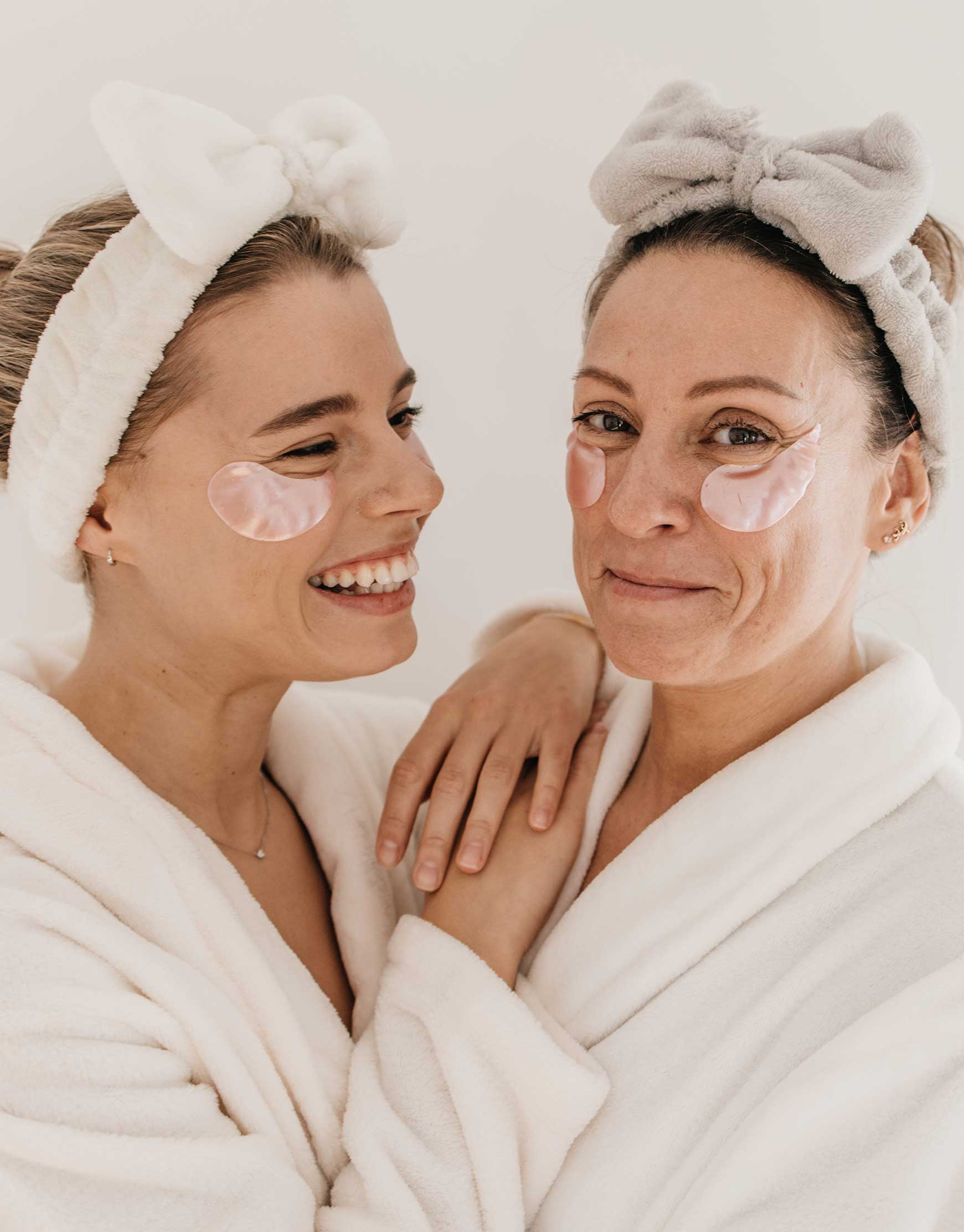 Deux femmes, une jeune et une plus âgée, appliquant des soins cosmétiques pour illustrer les tests et études produits dans le secteur cosmétique.